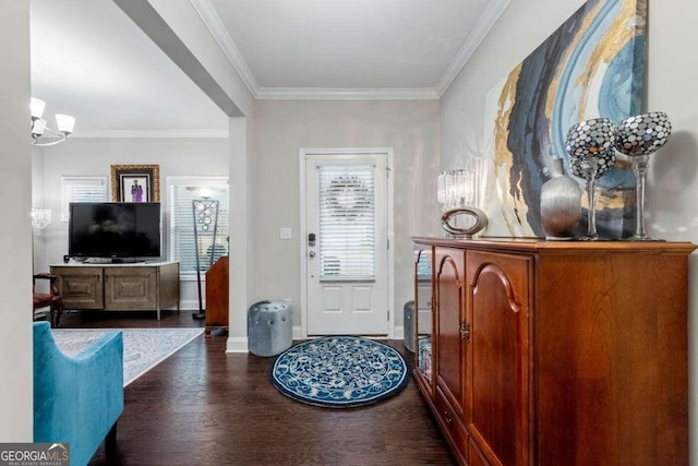 entryway featuring an inviting chandelier, dark hardwood / wood-style flooring, and ornamental molding