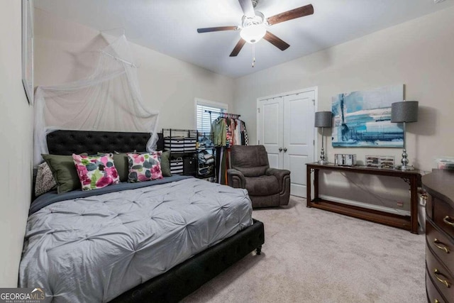 bedroom with light carpet, ceiling fan, and a closet