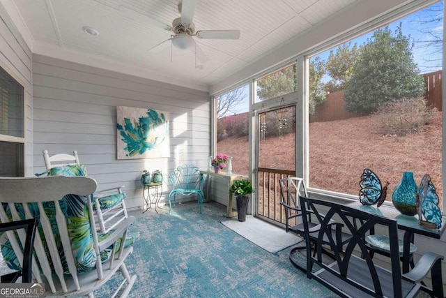 sunroom / solarium featuring ceiling fan