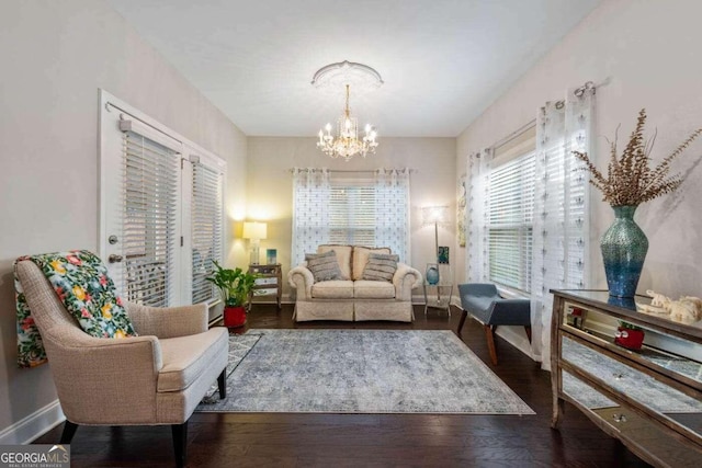 sitting room featuring dark wood-type flooring and a chandelier