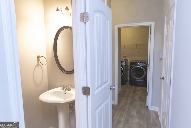 bathroom with washing machine and dryer and hardwood / wood-style flooring