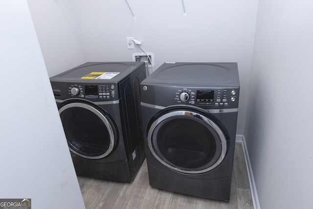 laundry area featuring hardwood / wood-style flooring and washing machine and clothes dryer