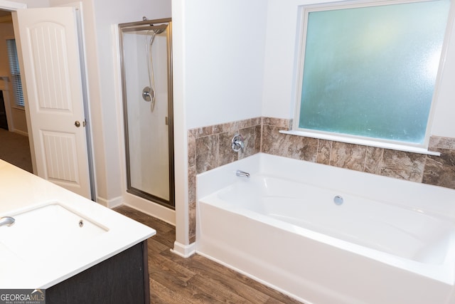 bathroom featuring vanity, plus walk in shower, and wood-type flooring