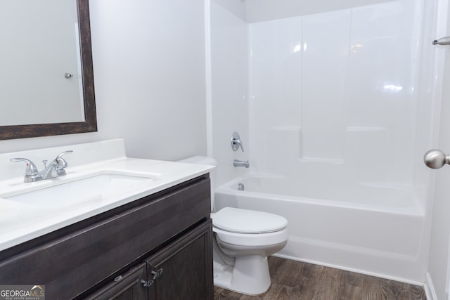 full bathroom featuring washtub / shower combination, hardwood / wood-style flooring, vanity, and toilet