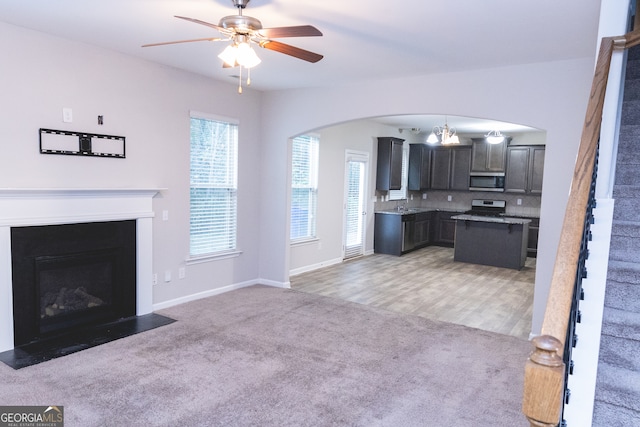 carpeted living room featuring ceiling fan and sink