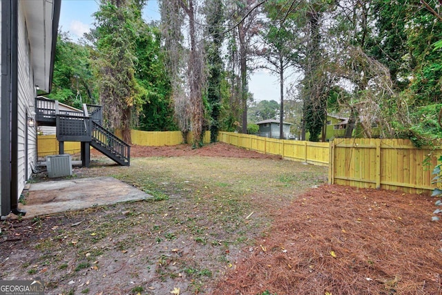 view of yard featuring a deck and central air condition unit