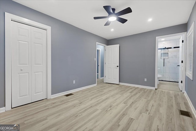 unfurnished bedroom featuring light hardwood / wood-style flooring, ceiling fan, connected bathroom, and a closet