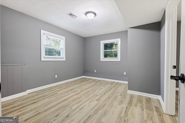 unfurnished room featuring light wood-type flooring and plenty of natural light