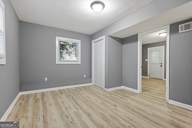 unfurnished bedroom with a closet and light wood-type flooring