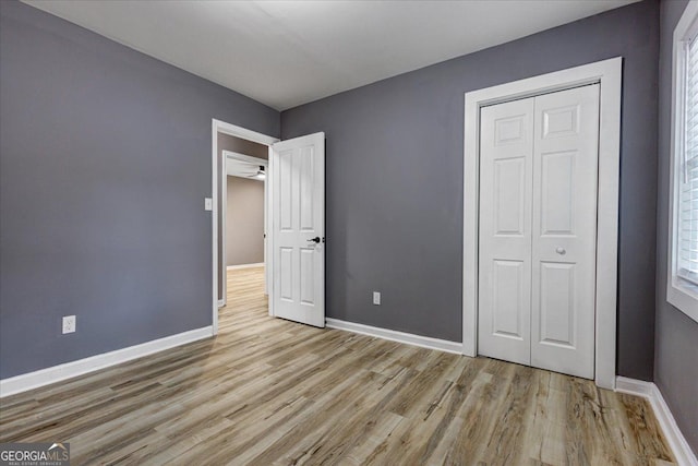 unfurnished bedroom featuring light hardwood / wood-style floors and a closet