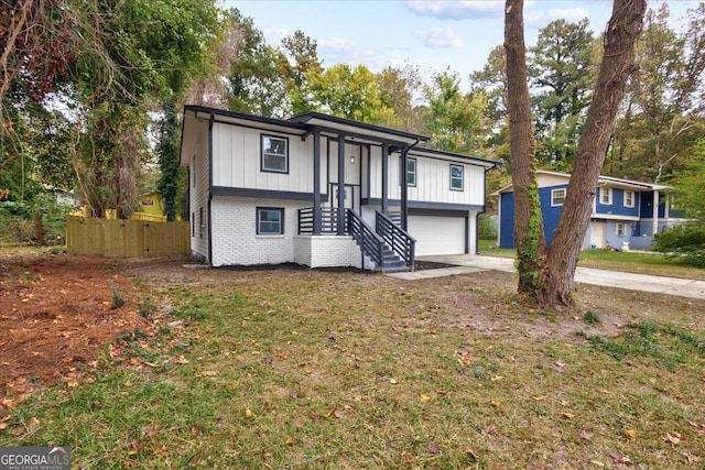 split foyer home featuring a garage and a front yard