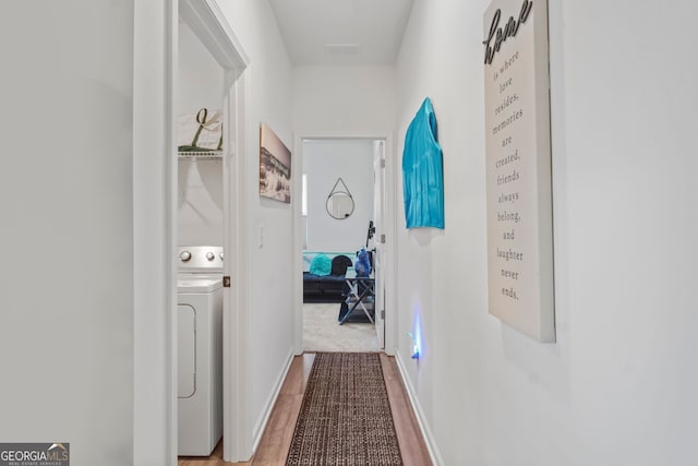 hallway with washer / dryer and hardwood / wood-style flooring