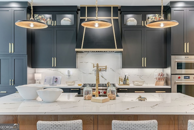 kitchen featuring hanging light fixtures, light stone countertops, and backsplash