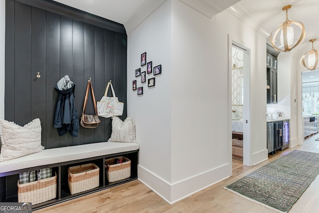 mudroom with light hardwood / wood-style floors and an inviting chandelier