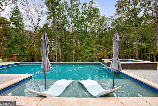 view of swimming pool featuring an in ground hot tub