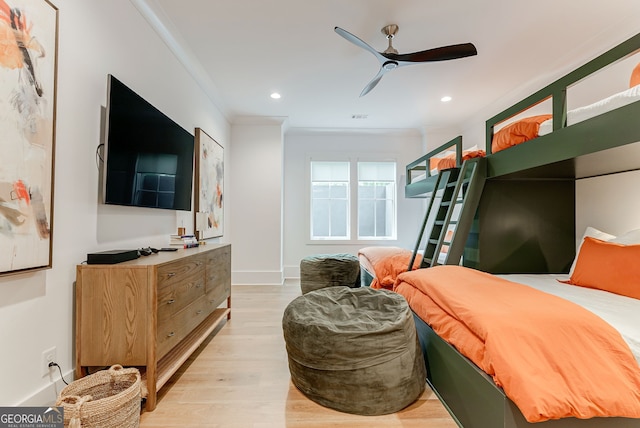 bedroom featuring light wood-type flooring, ceiling fan, and crown molding