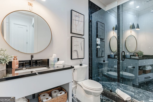 bathroom featuring vanity, toilet, and a shower with shower door