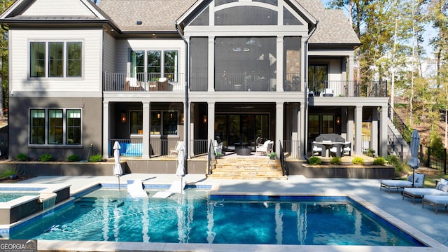 back of property with a patio area, a balcony, and a fenced in pool