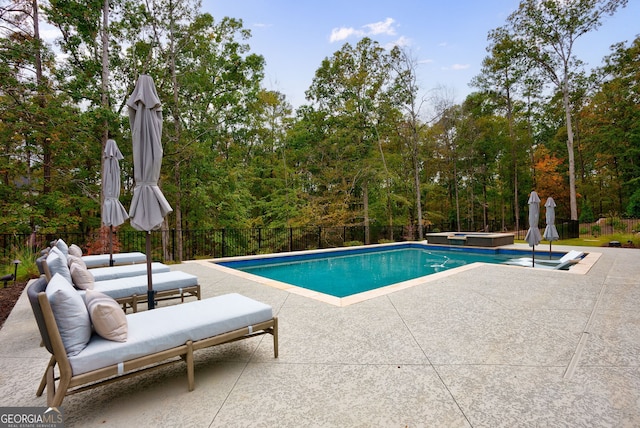 view of swimming pool featuring a hot tub and a patio area