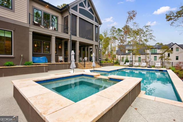 view of pool with an in ground hot tub