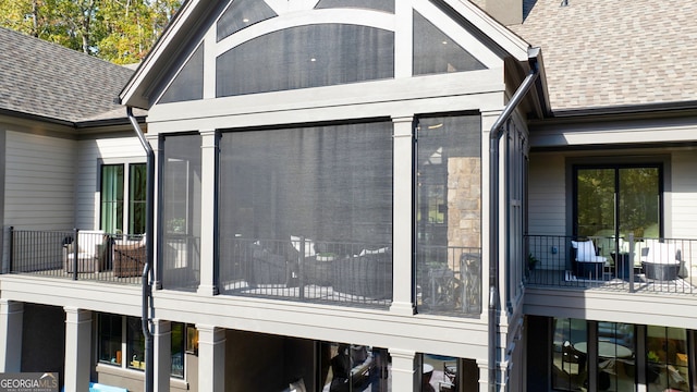 view of side of home with a sunroom and a balcony