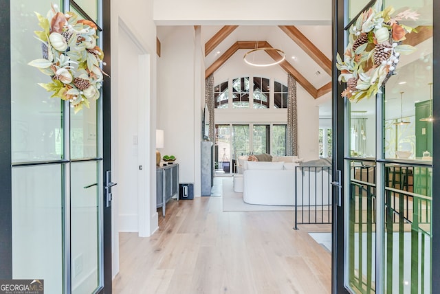 interior space featuring light hardwood / wood-style floors, beamed ceiling, and high vaulted ceiling