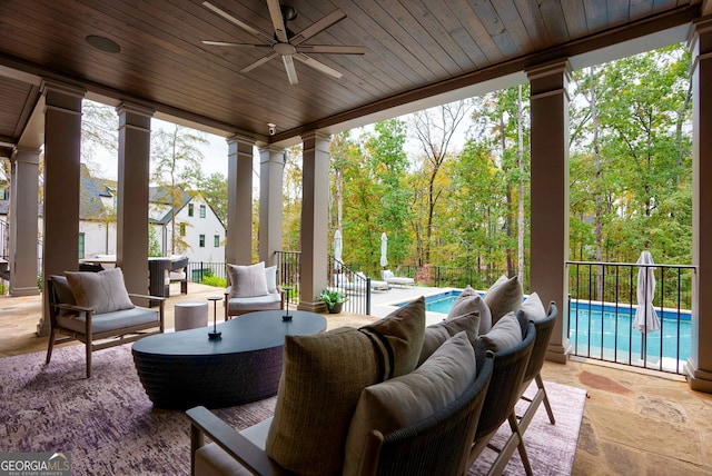 sunroom featuring ceiling fan, wood ceiling, and ornate columns