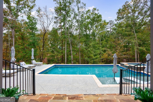 view of pool featuring a patio area and an in ground hot tub