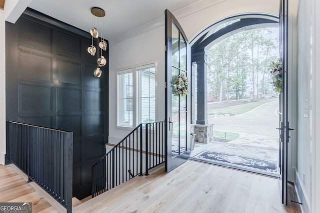 foyer entrance with hardwood / wood-style floors and crown molding