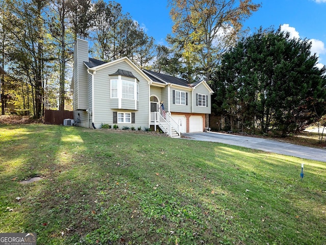 bi-level home featuring central AC unit, a garage, and a front lawn