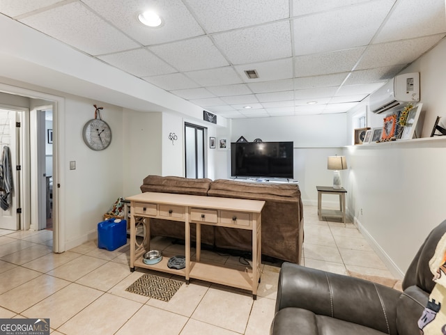 tiled living room with an AC wall unit and a drop ceiling