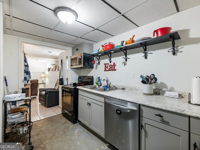 kitchen with gray cabinetry, a drop ceiling, sink, and stainless steel appliances