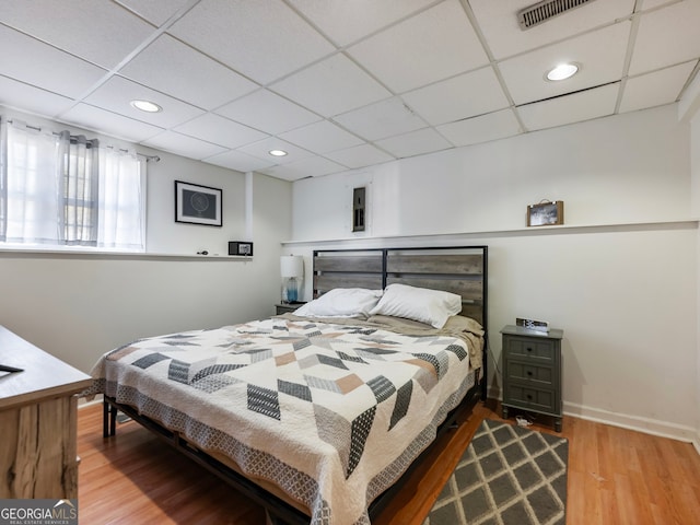 bedroom featuring hardwood / wood-style flooring and a paneled ceiling