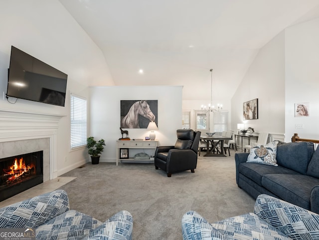 carpeted living room with a notable chandelier, high vaulted ceiling, and a tiled fireplace