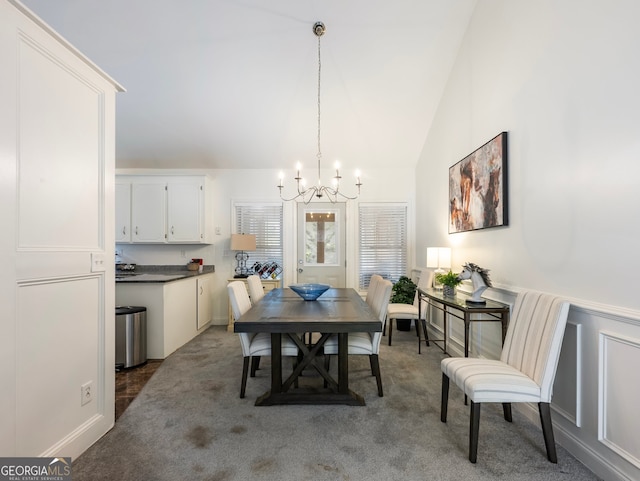 dining area featuring carpet floors, an inviting chandelier, and vaulted ceiling