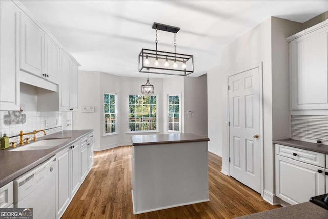 kitchen with white cabinetry, dishwasher, sink, dark wood-type flooring, and pendant lighting