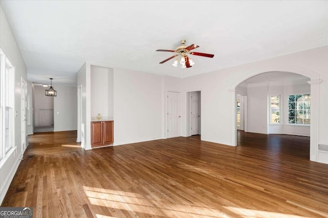 unfurnished living room featuring hardwood / wood-style floors and ceiling fan with notable chandelier