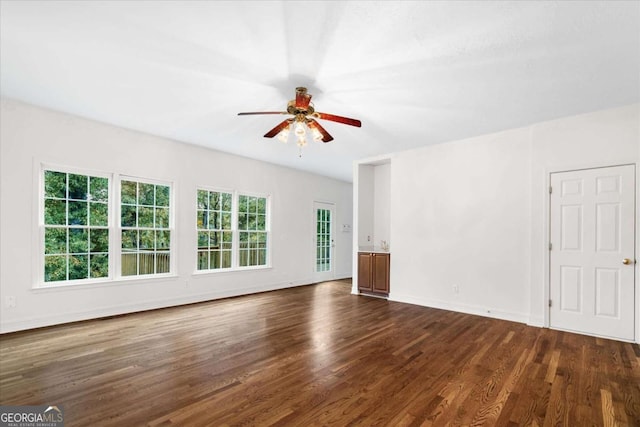 unfurnished living room featuring ceiling fan and dark wood-type flooring