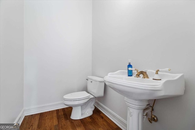 bathroom with hardwood / wood-style flooring and toilet