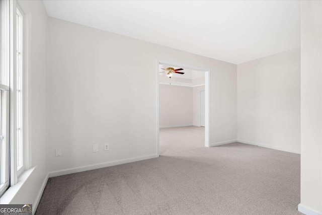 spare room featuring ceiling fan and light colored carpet