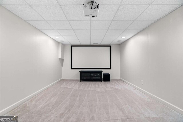 home theater room with a drop ceiling and light colored carpet