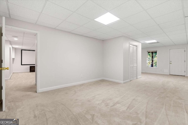 unfurnished room with a paneled ceiling and light carpet