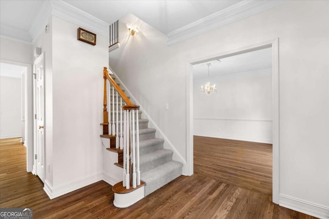 stairway with wood-type flooring, an inviting chandelier, and crown molding