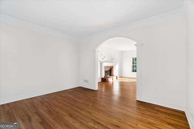 unfurnished living room with a fireplace, hardwood / wood-style floors, and crown molding