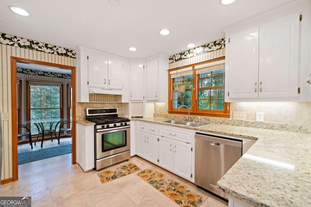 kitchen featuring white cabinets, appliances with stainless steel finishes, sink, and range hood