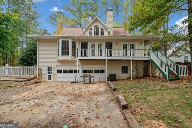 back of property with a garage and central air condition unit