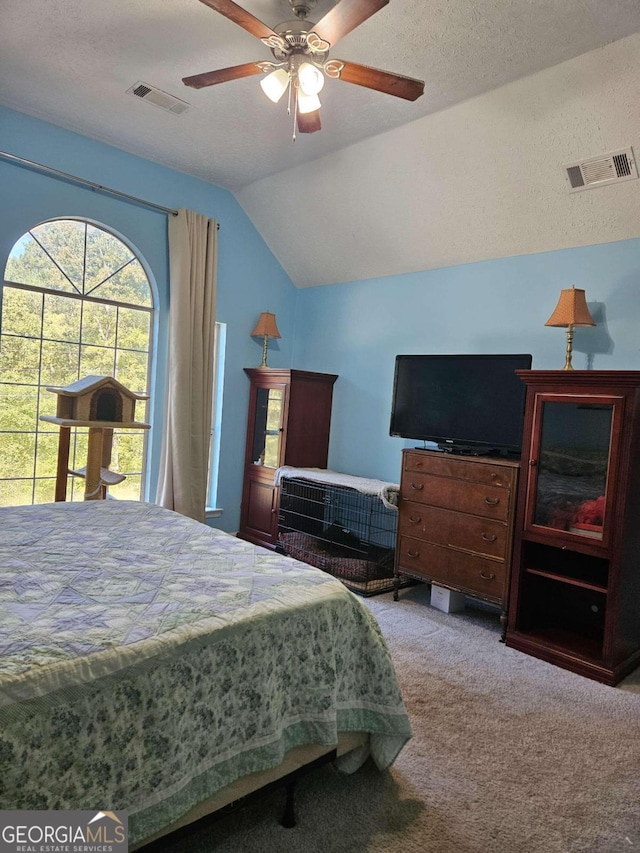 bedroom with lofted ceiling, ceiling fan, a textured ceiling, and carpet floors