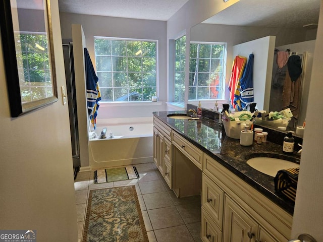 bathroom with vanity, a textured ceiling, tile patterned floors, and plus walk in shower