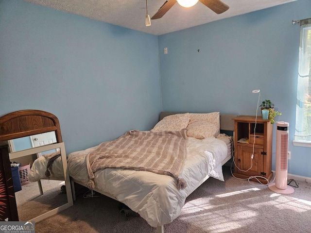 carpeted bedroom with a textured ceiling and ceiling fan