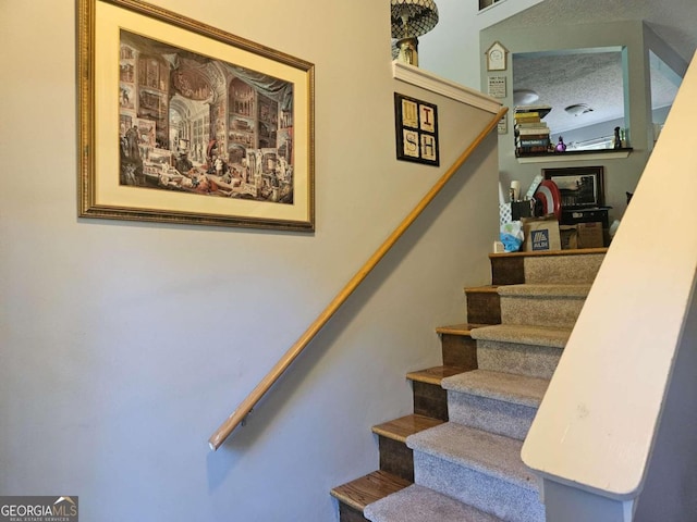 staircase with a textured ceiling